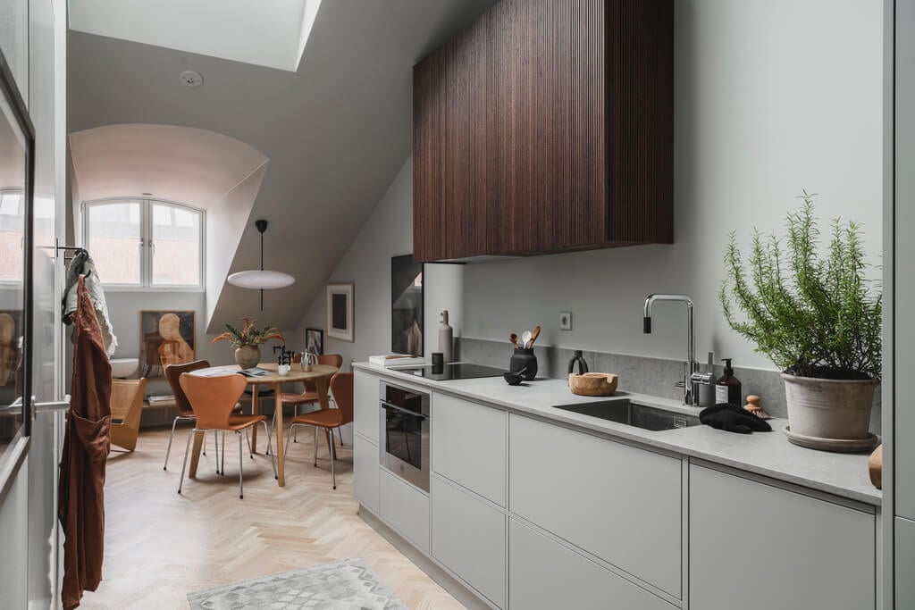 A Stylish Modern Gray Attic Apartment 8 modern-scandinavian-kitchen-light-gray-lower-cabinets-wood-upper-cabinets-nordroom