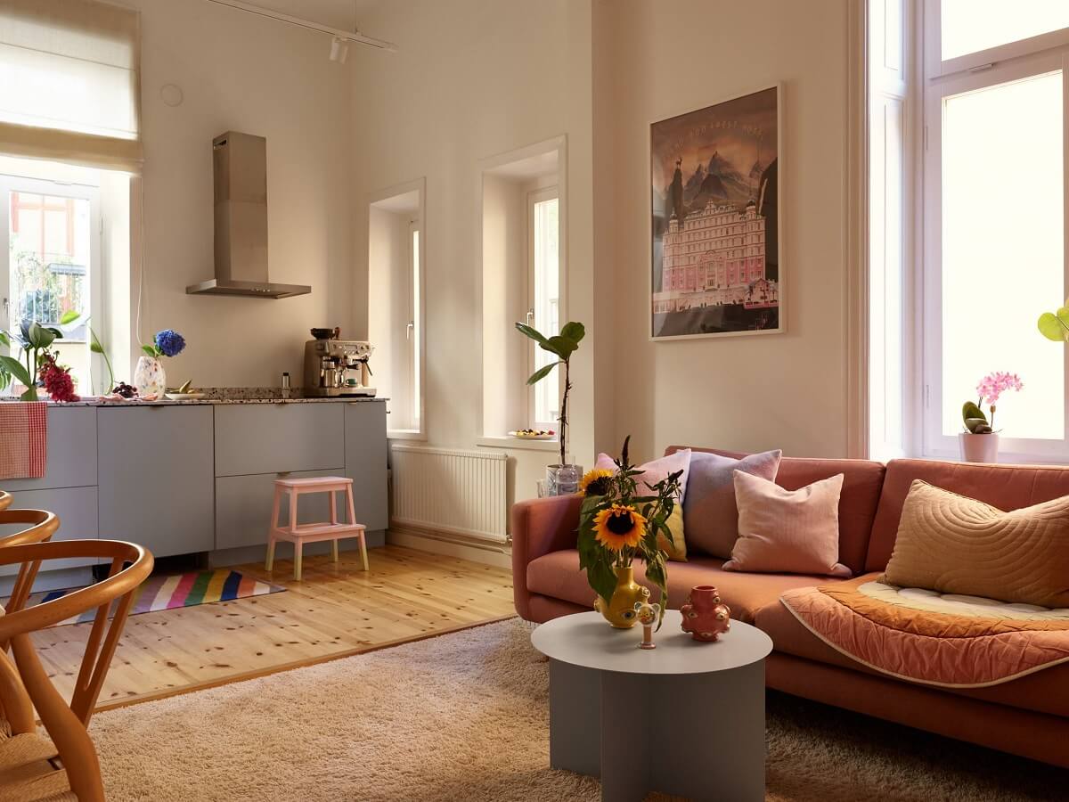 A Small Stockholm Apartment Filled with Color 5 open-plan-living-room-kitchen-pink-sofa-nordroom