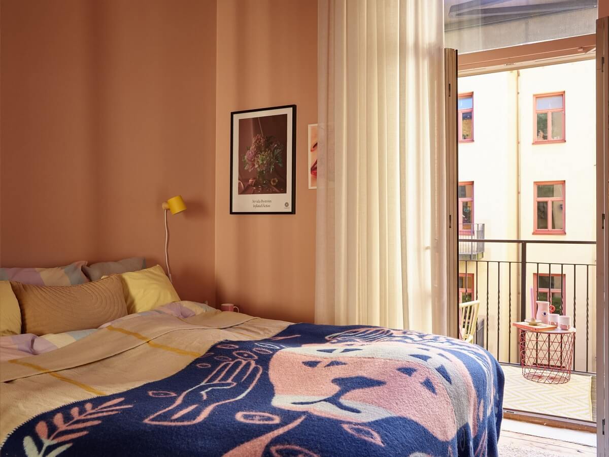 A Small Stockholm Apartment Filled with Color 13 pink-bedroom-balcony-blue-throw-nordroom