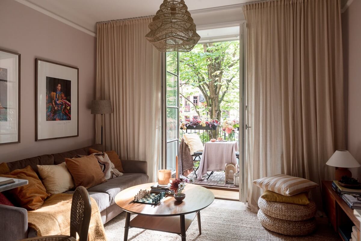 A Charming Open Plan Swedish Apartment 2 pink-walls-earthy-cushions-living-room-nordroom
