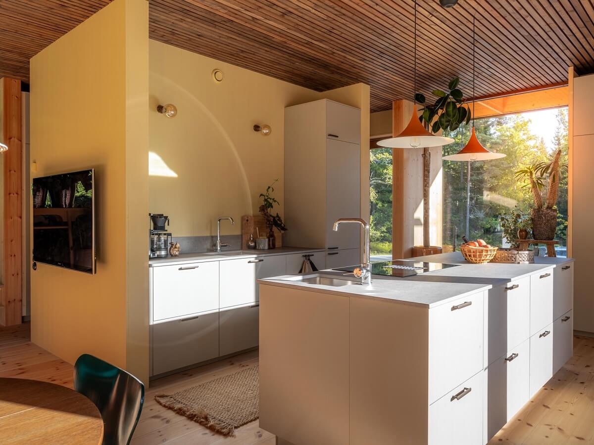 An Architectural Wooden Home with Open Spaces 8 scandinavian-kitchen-with-island-yellow-accent-wall-nordroom