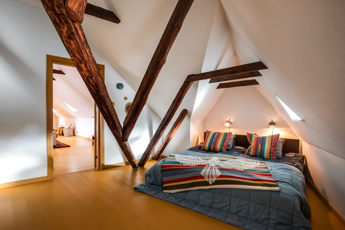 A Unique Bohemian Family Home in a Former Swedish Bakery 36 bedroom-pitched-ceiling-wooden-beams-yellow-floor-nordroom