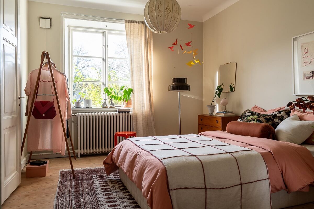 Colorful Decor in a Scandinavian Apartment 12 beige-bedroom-pink-bedding-scandinavian-design