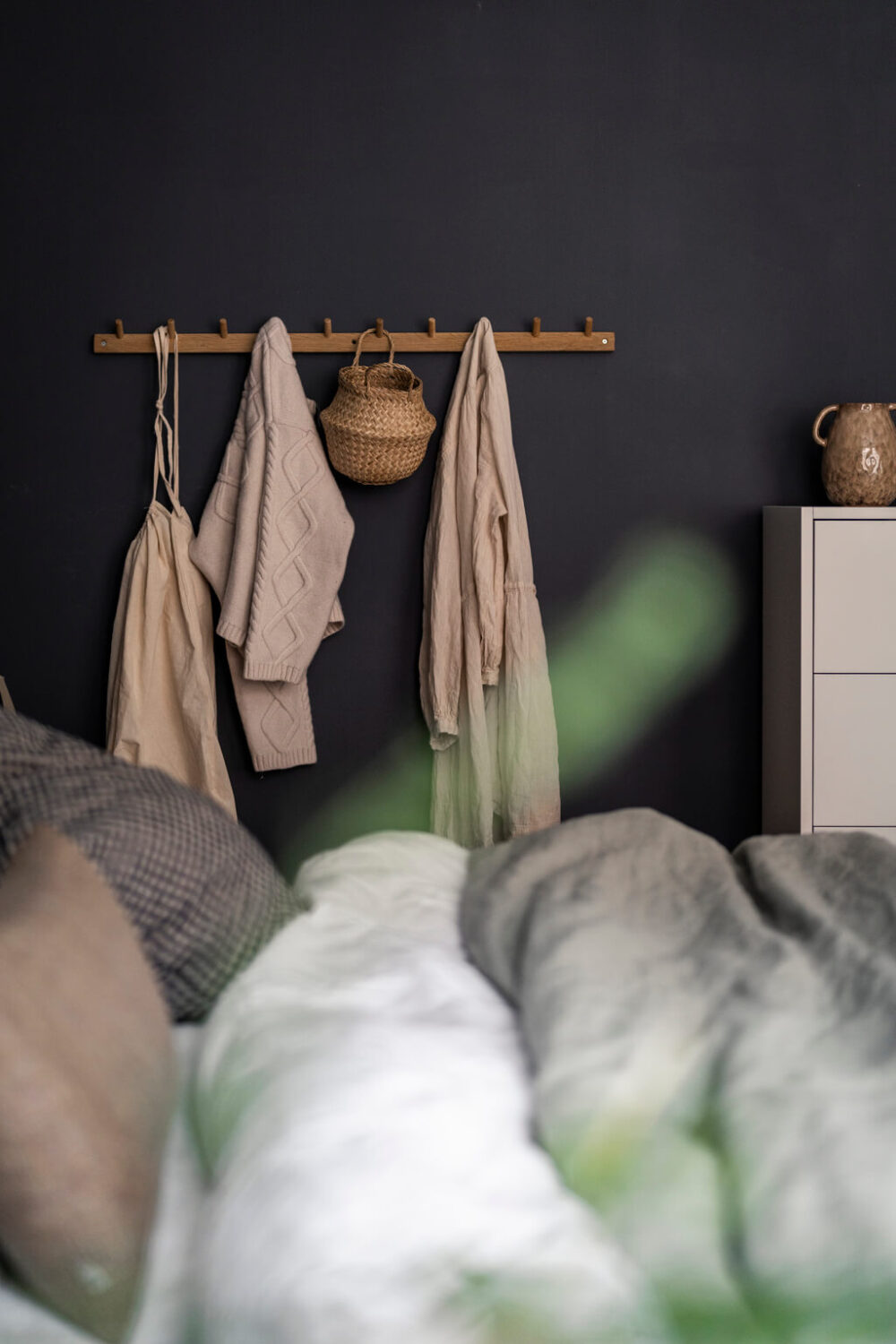 A Scandinavian Studio Apartment with Black Walls 9 black wall clothing hooks