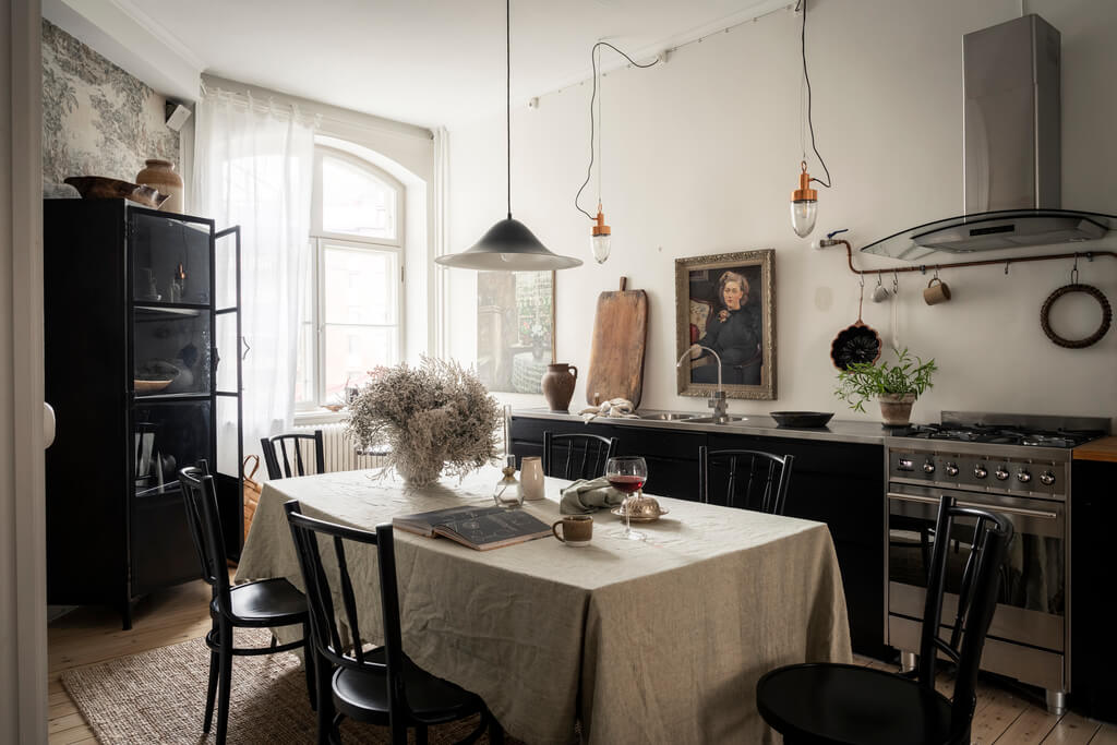 A Scandinavian Studio Apartment with Black Walls 18 black white kitchen large dining table