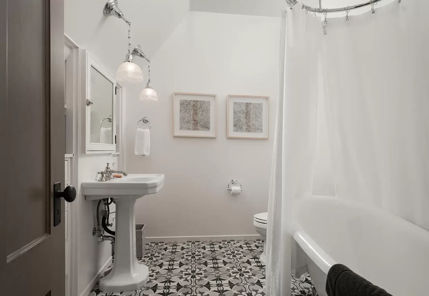 A Cozy Montecito Home Once Owned by Larry David 21 bright bathroom white wall tiles black white floor tiles freestanding bath