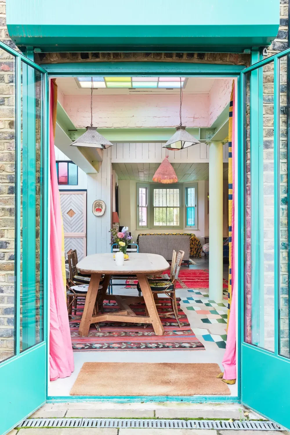 A Playful Colorful Eclectic Artist Home in London 5 green window trims dining space
