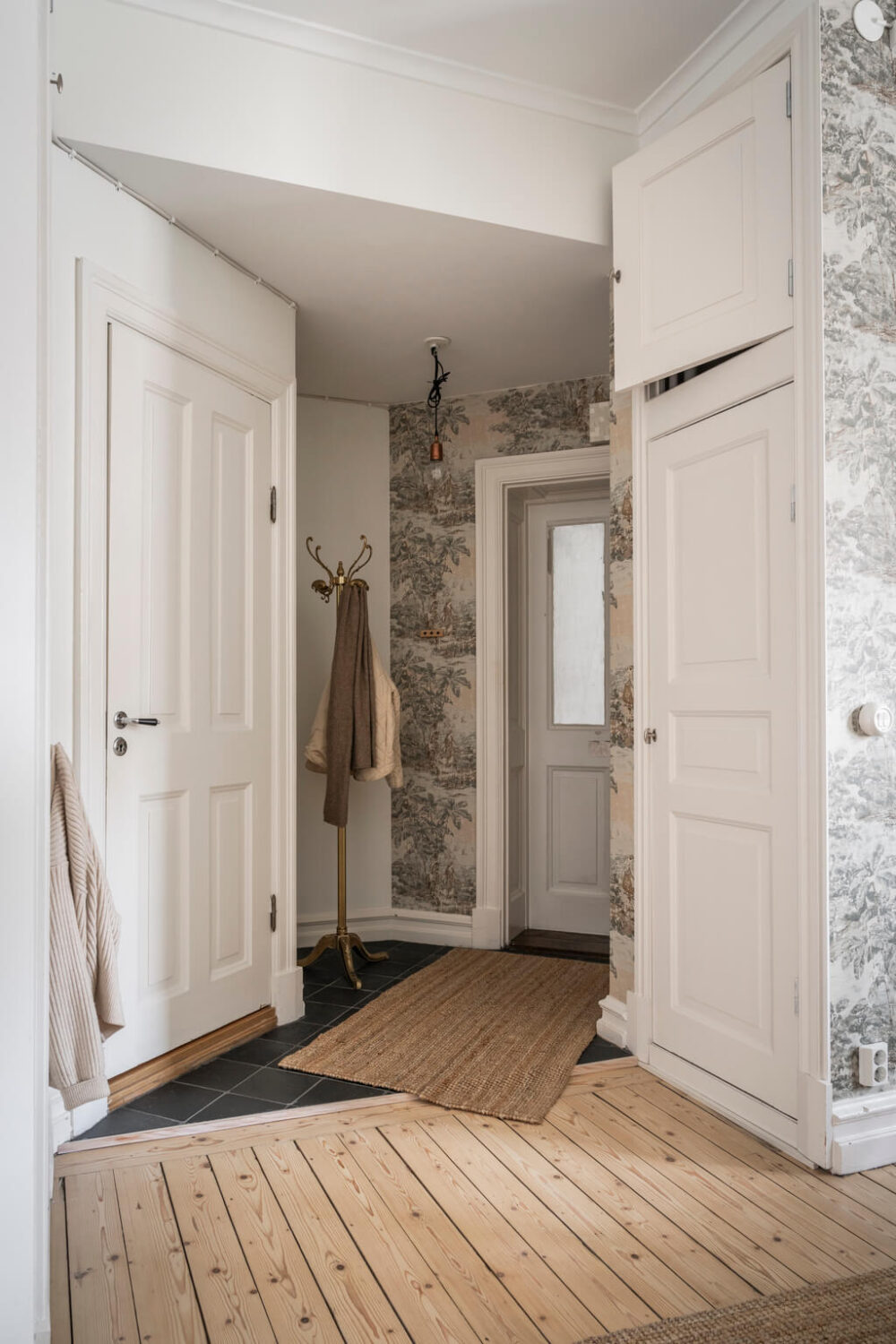 A Scandinavian Studio Apartment with Black Walls 22 hallway built in wardrobes wooden floor
