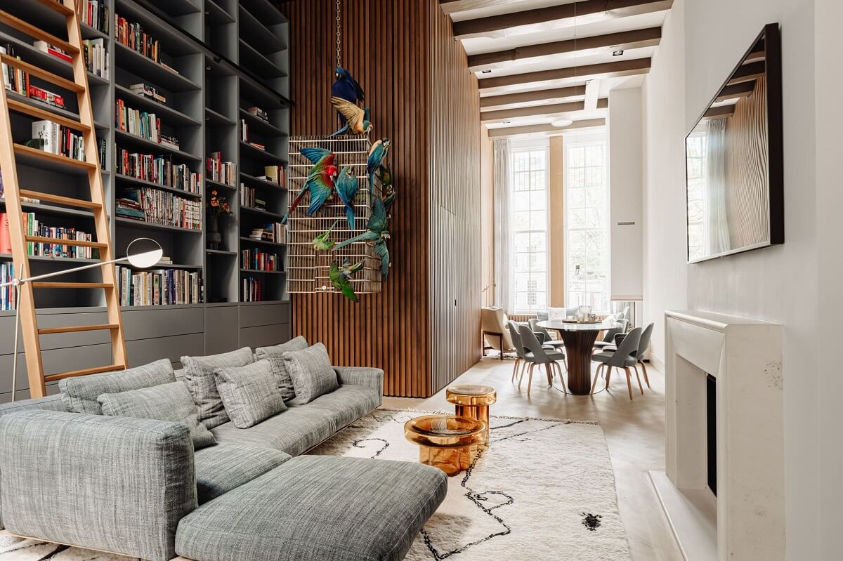 A Luxurious Amsterdam Canal House with High Ceilings 1 living room wooden accent wall bookcases amsterdam canal house