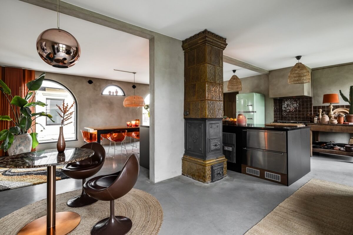 A Unique Bohemian Family Home in a Former Swedish Bakery 16 open-plan-kitchen-dining-room-green-fireplace