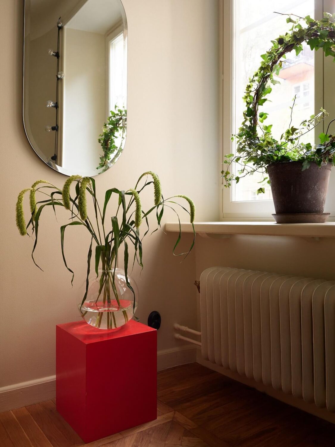 A Serene Light Colored Apartment with Bright Color Pops 10 red side table oval mirror