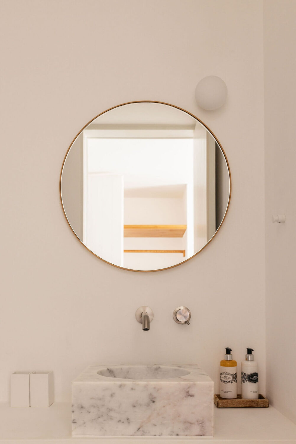 A Renovated 19th Century House with a Minimalistic Decor 12 round-mirror-marble-sink-bathroom