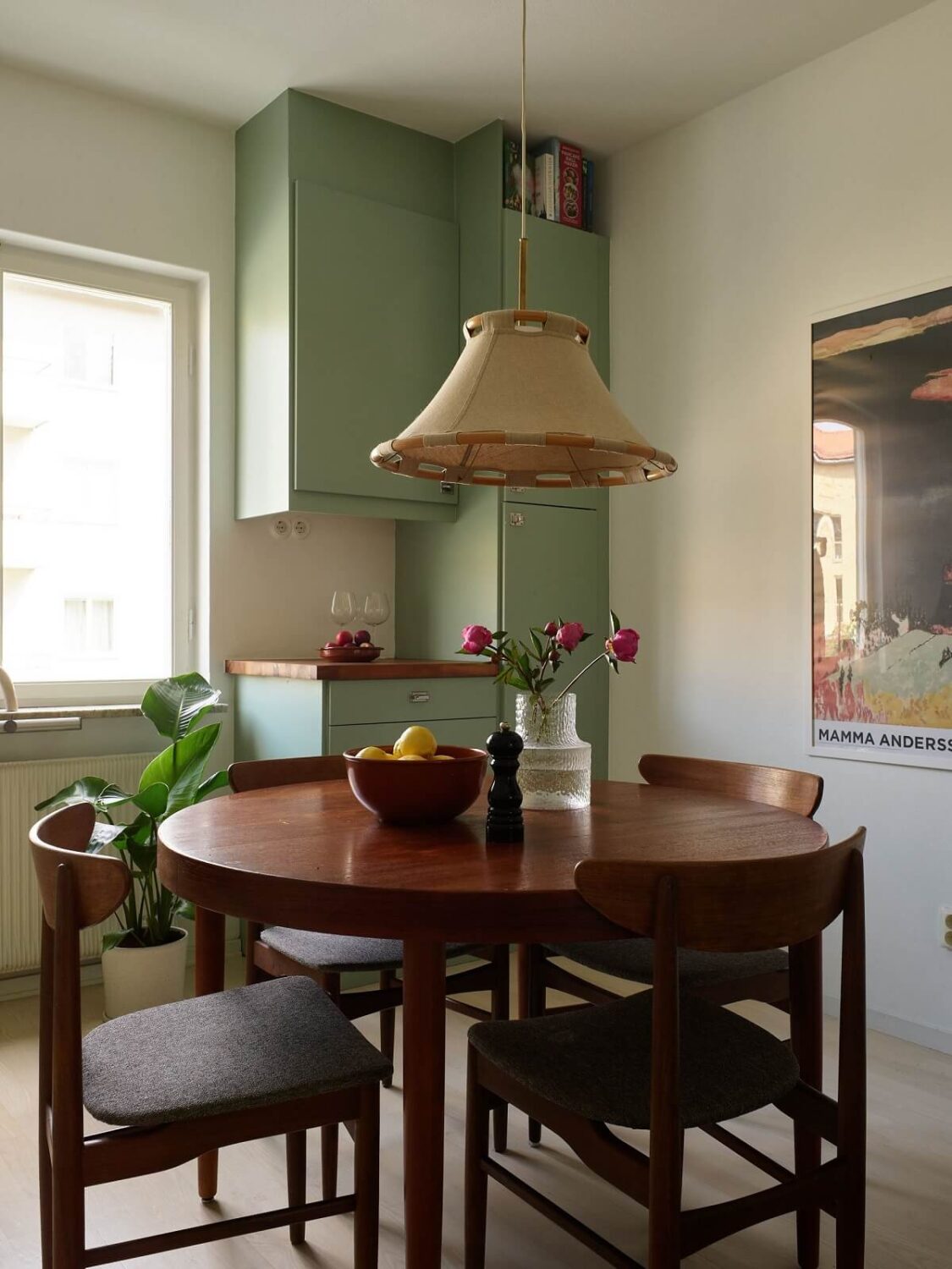 Soft Yellow Walls in a Swedish Apartment 10 round-wooden-dining-table-green-cabinets-nordroom