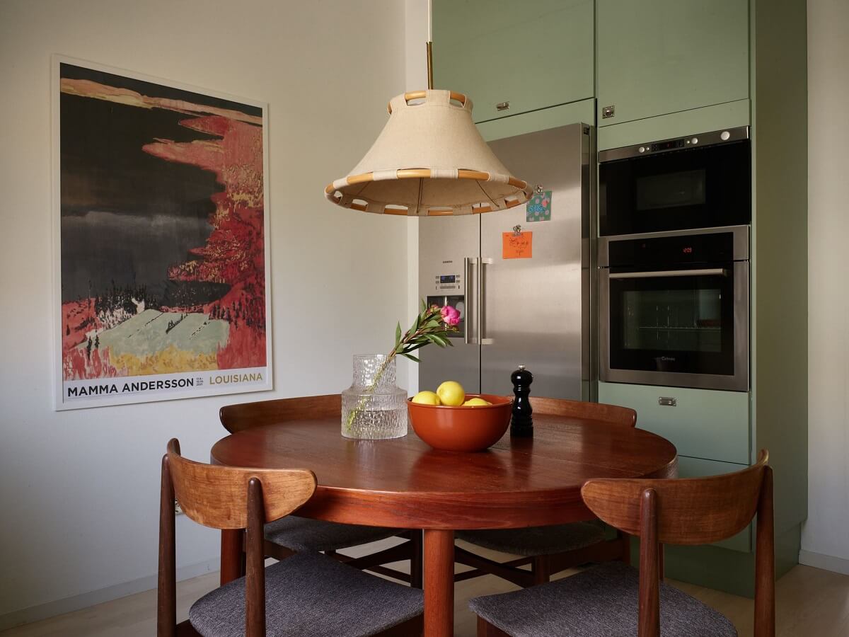 Soft Yellow Walls in a Swedish Apartment 11 round-wooden-dining-table-green-kitchen-cabinets