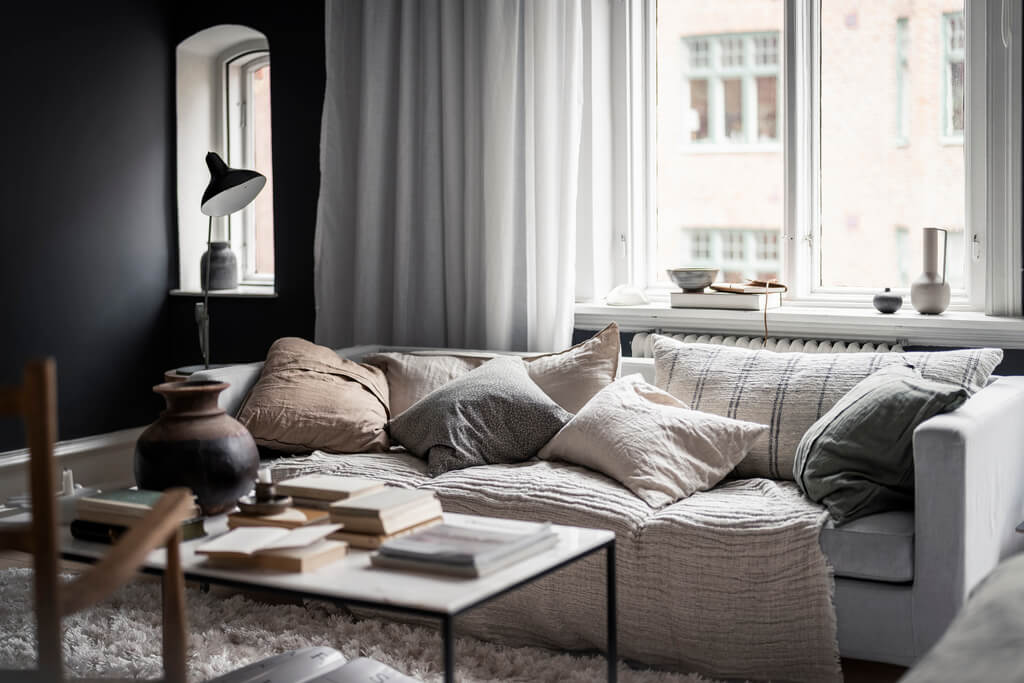 A Scandinavian Studio Apartment with Black Walls 4 sofa cushions swedish studio apartment
