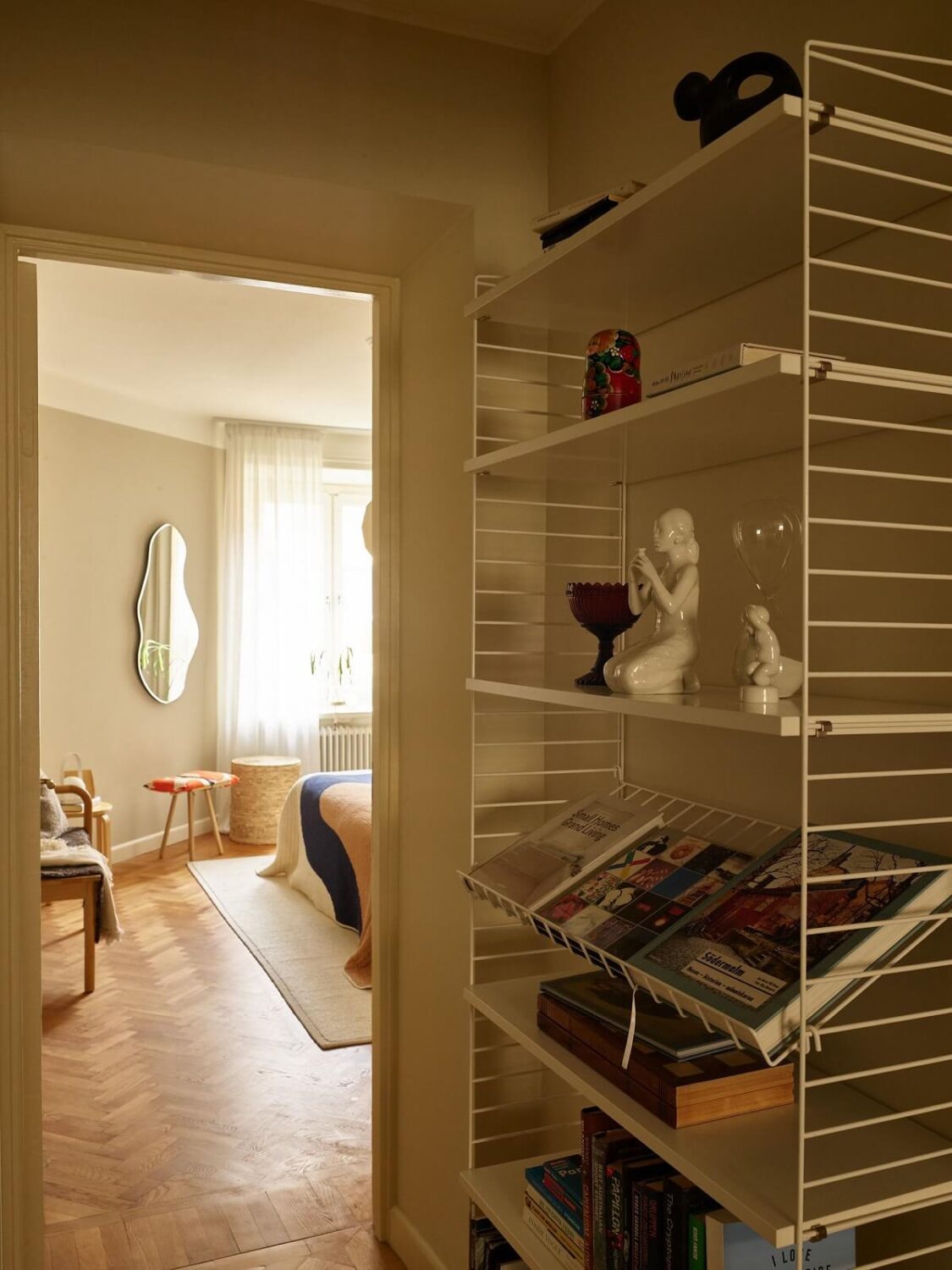 A Serene Light Colored Apartment with Bright Color Pops 14 string shelves hallway