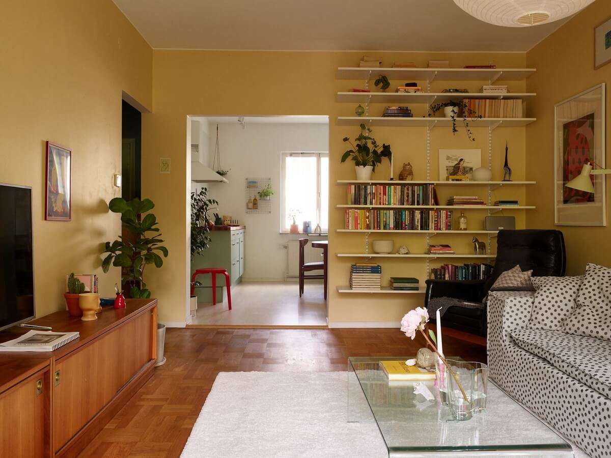 Soft Yellow Walls in a Swedish Apartment 8 yellow-living-room-polkadot-sofa-bookshelves-nordroom