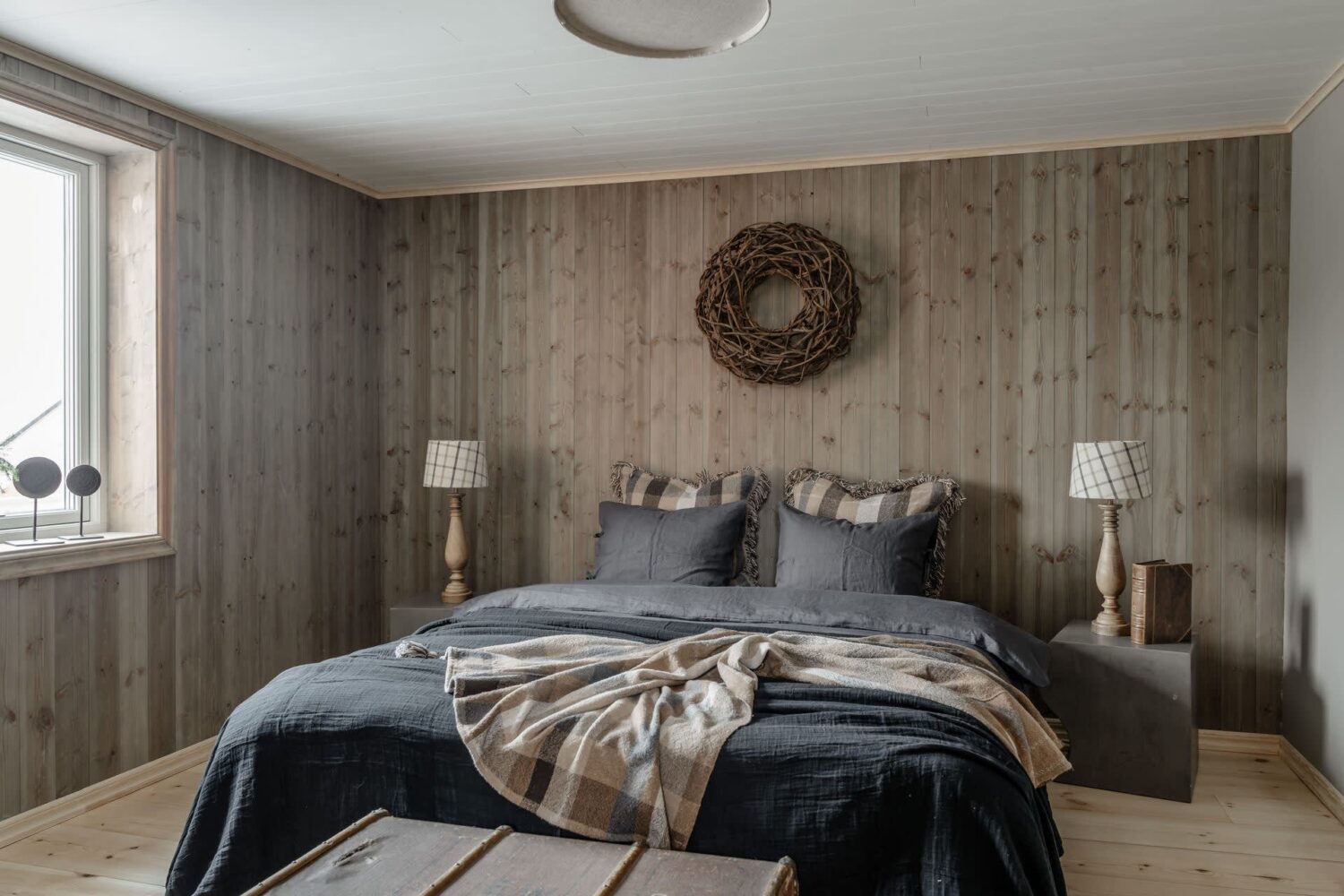 A Cozy Log House in Sweden 17 bedroom-wooden-walls-gray-bedding-nordroom