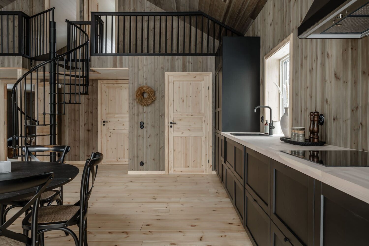 A Cozy Log House in Sweden 13 black-kitchen-spiral-staircase