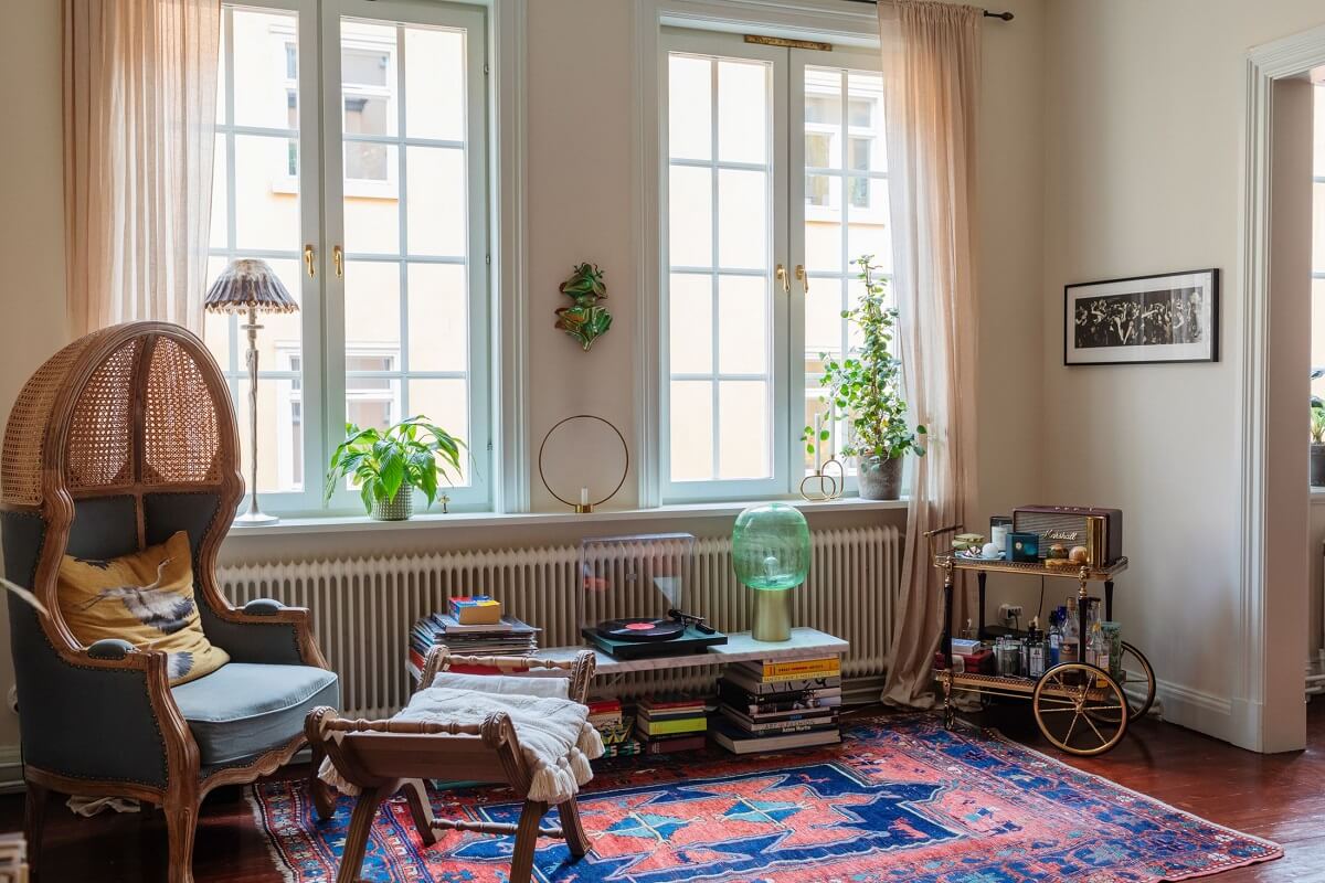 A Cozy Swedish Apartment with a Green Kitchen 2 cozy living room large rug armchair