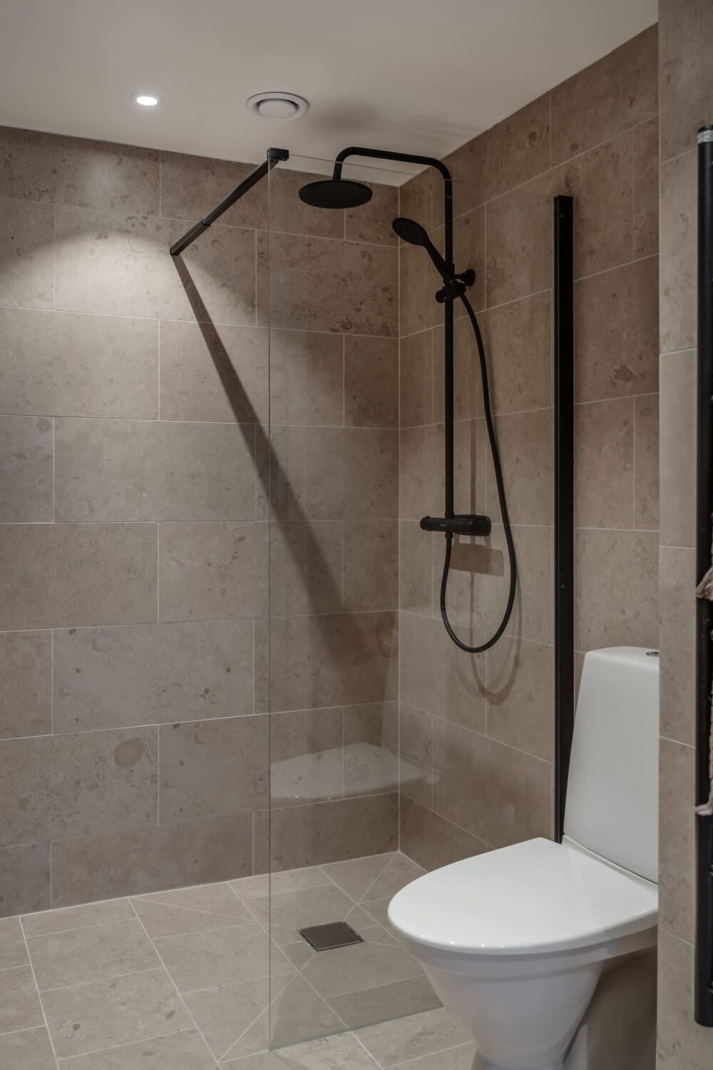 A Cozy Log House in Sweden 19 gray-bathroom-black-fittings-nordroom
