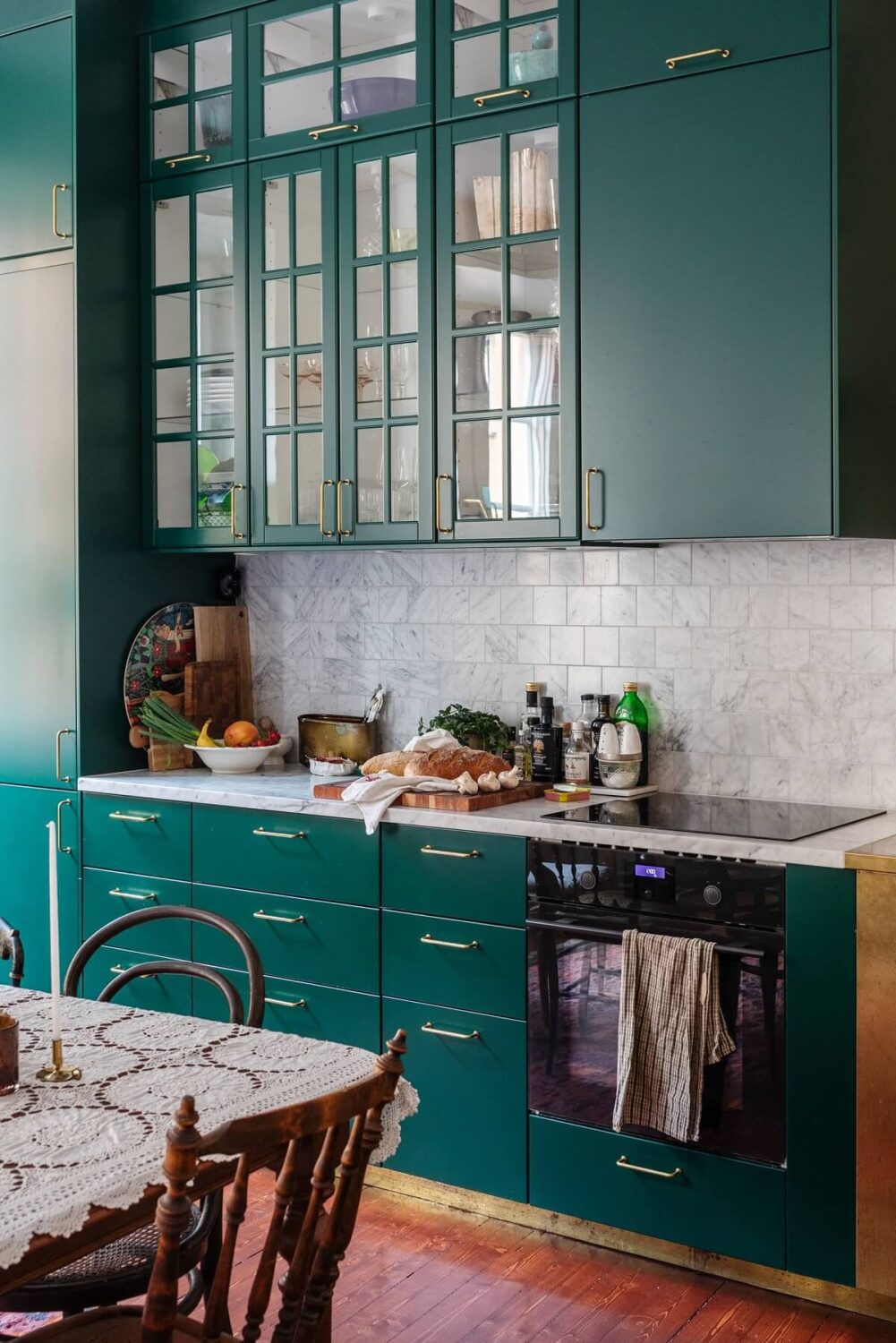 A Cozy Swedish Apartment with a Green Kitchen 8 green kitchen cabinets brass fittings