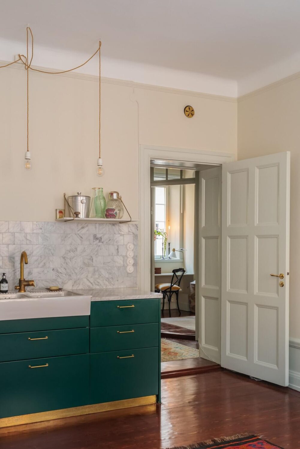 A Cozy Swedish Apartment with a Green Kitchen 13 green kitchen cabinets with brass accents