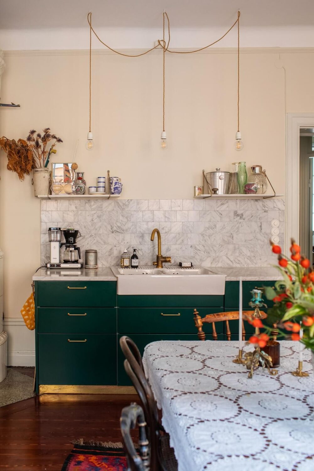 A Cozy Swedish Apartment with a Green Kitchen 9 green kitchen cabnets butler sink brass handles