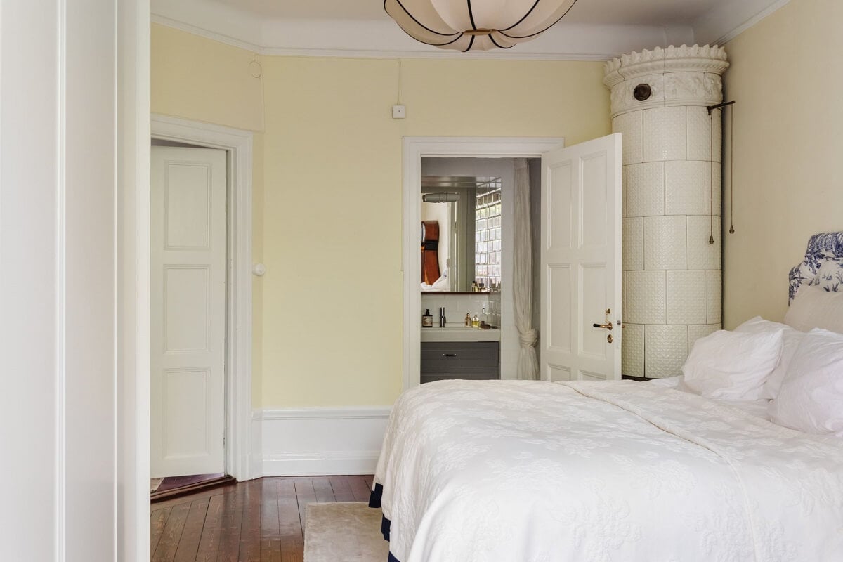 A Cozy Swedish Apartment with a Green Kitchen 27 serene light bedroom beige walls fireplace