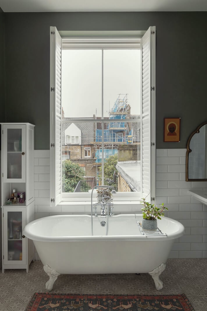 A Victorian House in London with Three Outdoor Spaces 20 bathroom freestanding bath in front of window gray walls nordroom