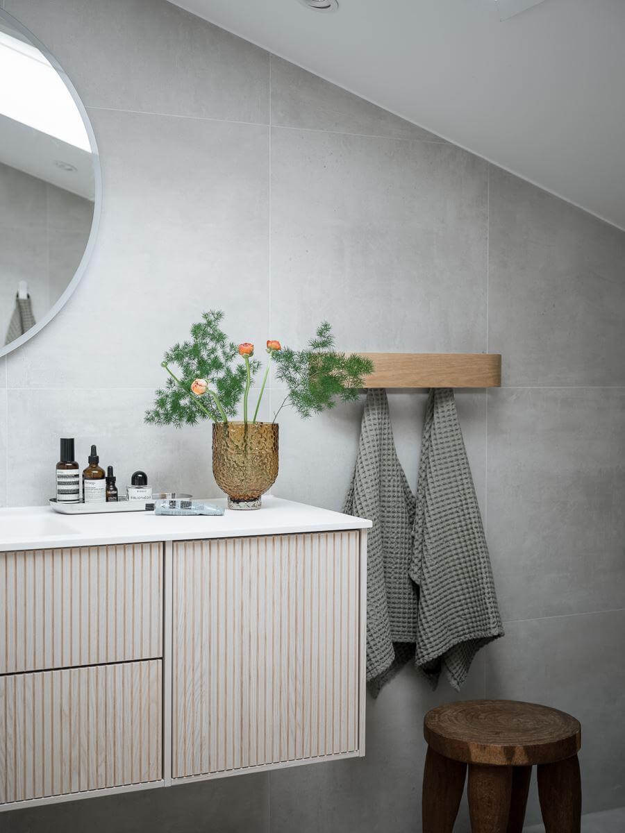 A Light-Filled Swedish Duplex is a Lovely Family Home 30 bathroom slanted ceiling gray walls ribbed vanity cabinet nordroom