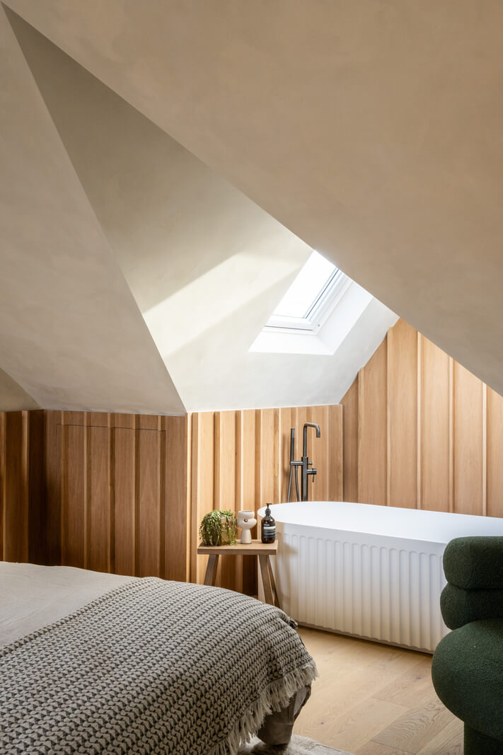 A Renovated Victorian House with Oak Features 19 bedroom slanted ceiling with freestanding bath and wooden walls nordroom