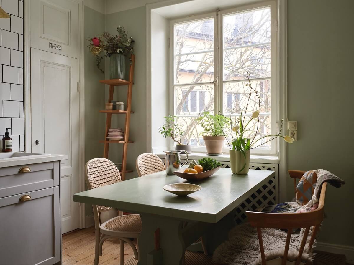 A Charming Swedish Apartment with a Cottage-Style Kitchen 13 country style swedish kitchen green table nordroom