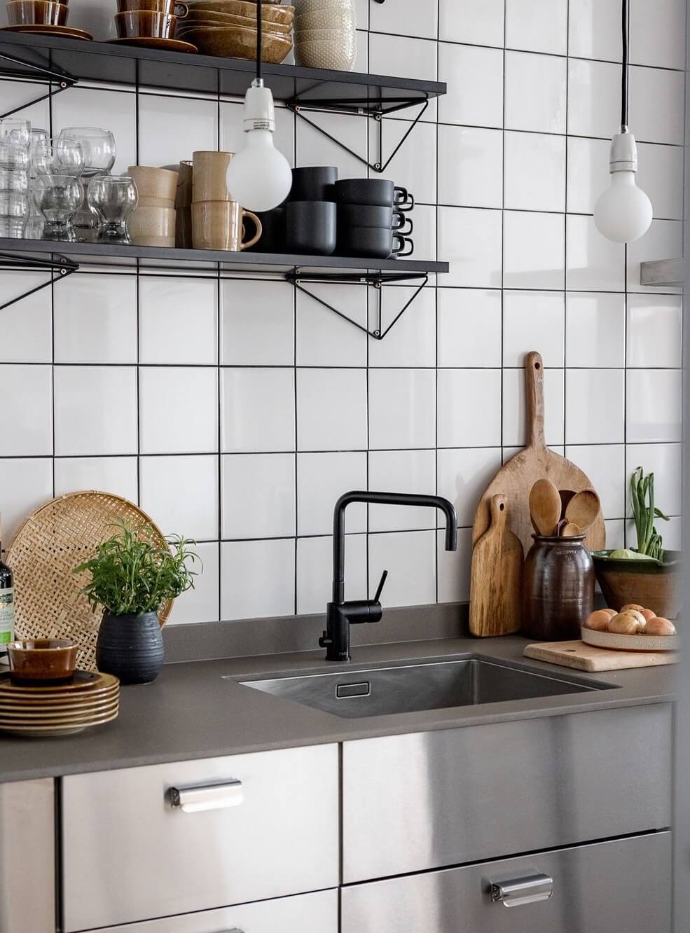 A Light Apartment with a Stainless Steel Kitchen 13 detail stainless steel kitchen black faucet shelves nordroom