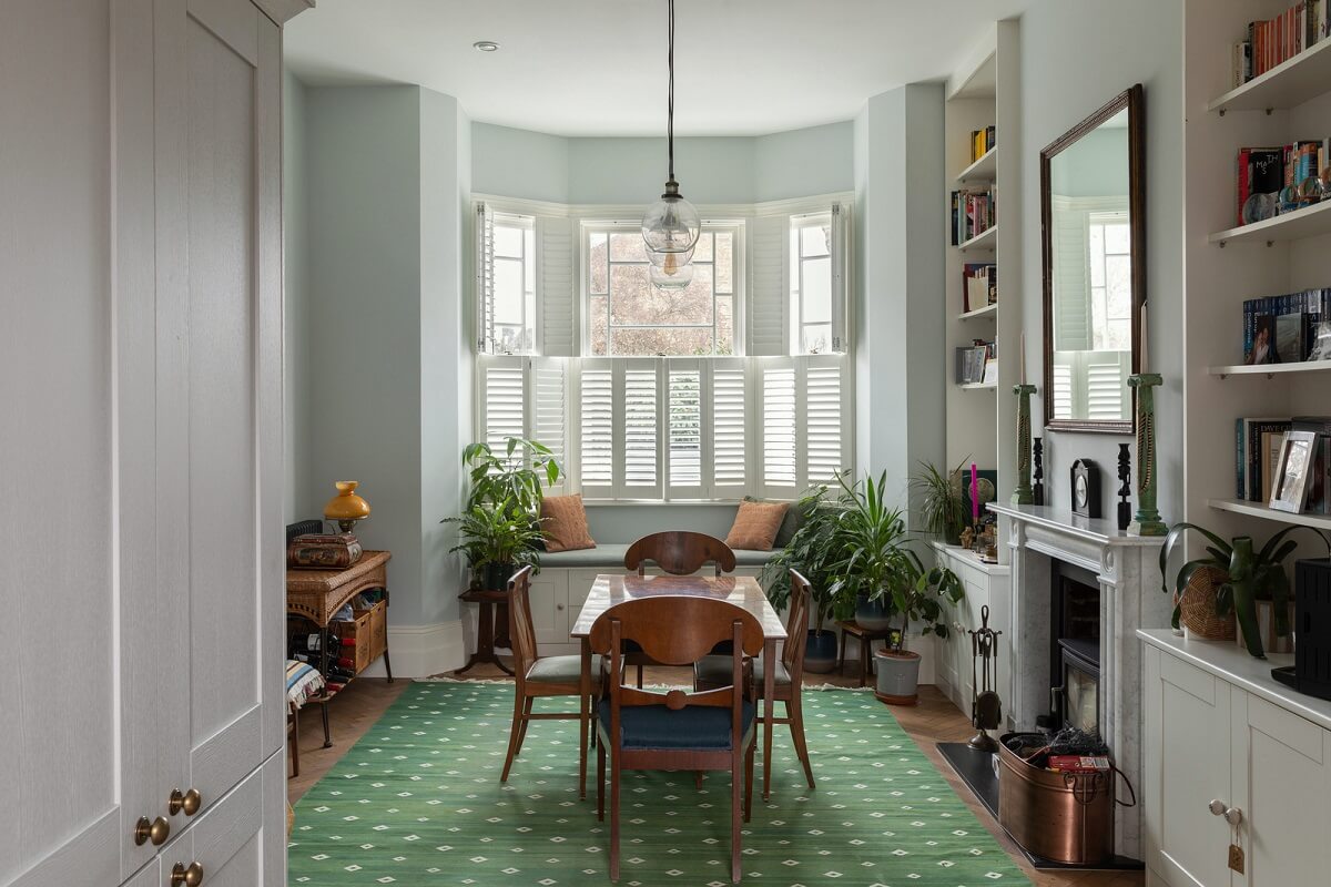 A Victorian House in London with Three Outdoor Spaces 1 dining room with green rug and fireplace nordroom