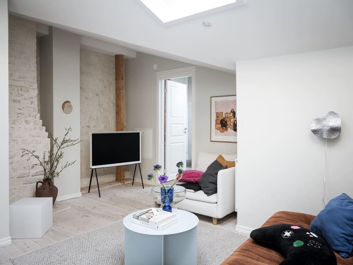 A Light-Filled Swedish Duplex is a Lovely Family Home 23 first floor living room white painted brick wall skylight nordroom