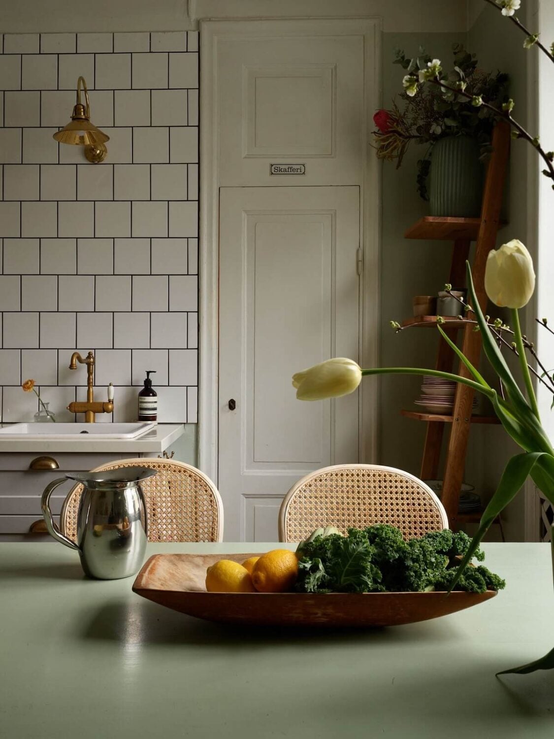 A Charming Swedish Apartment with a Cottage-Style Kitchen 14 green dining table detail