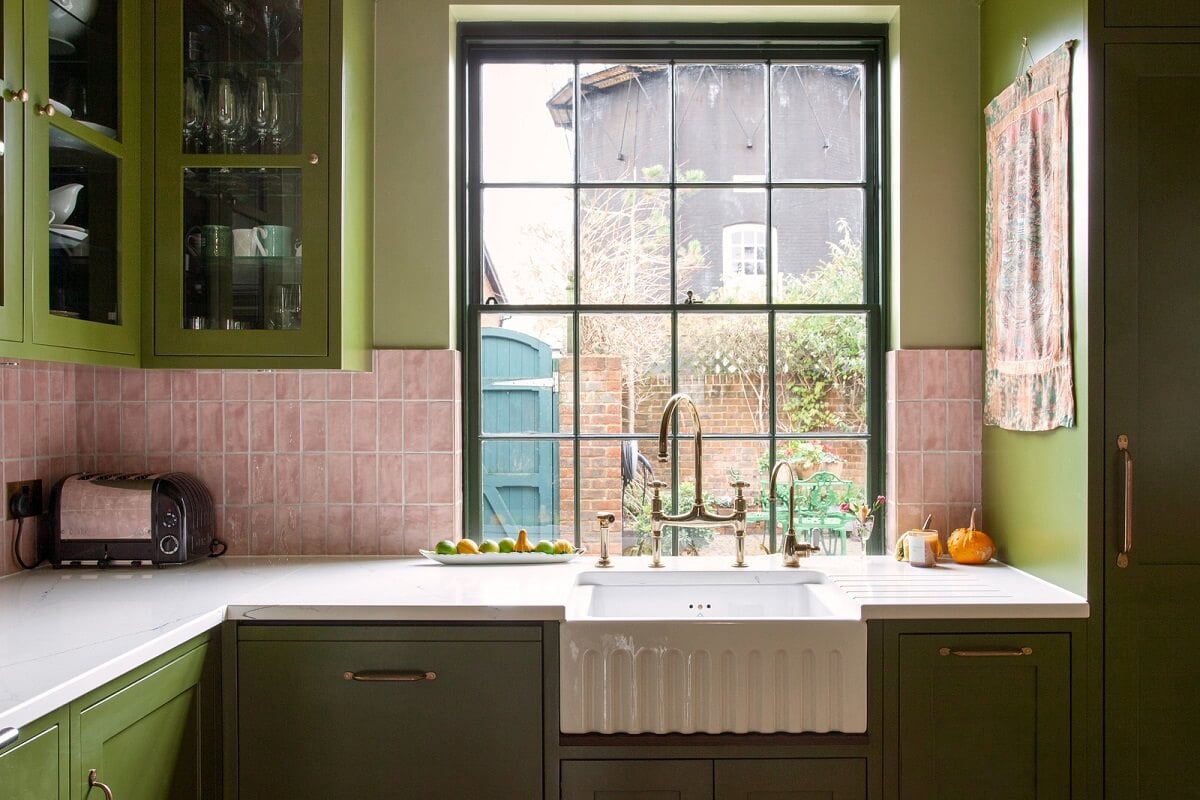 Bold Colors in a Charming Historic House in England 12 green-kitchen-cabinets-butler-sink-pink-tiles-nordroom