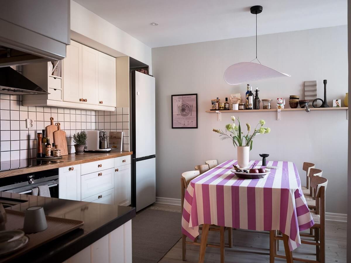 A Light-Filled Swedish Duplex is a Lovely Family Home 9 kitchen with dining table and pink striped tabe cloth nordroom