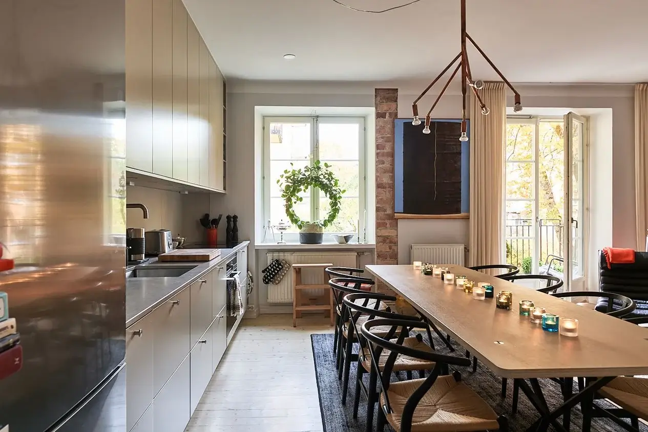 An Art-Filled Scandinavian Apartment 12 large-dining-table-black-wishbone-chairs-beige-kitchen-nordroom