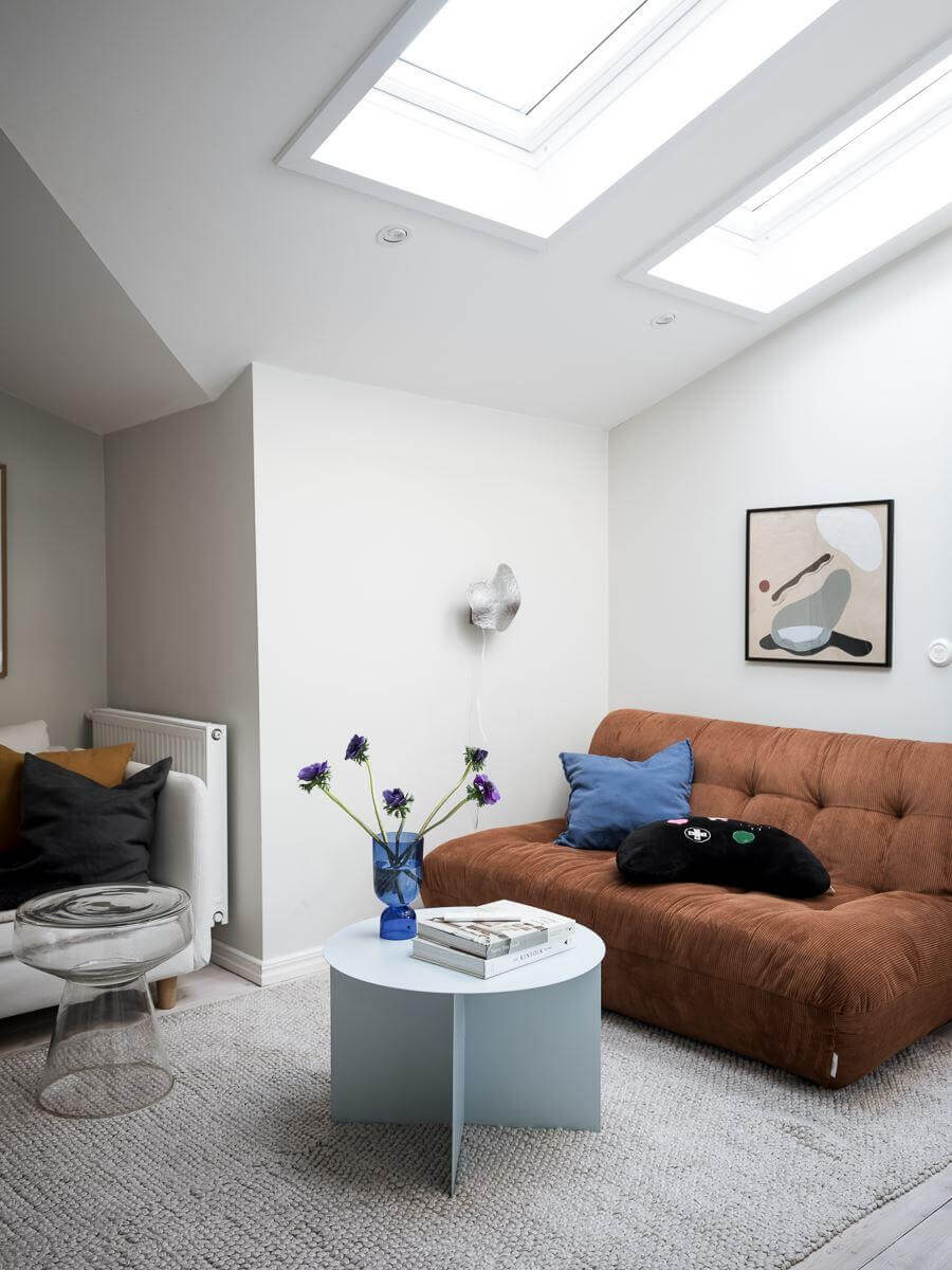 A Light-Filled Swedish Duplex is a Lovely Family Home 24 living room with brown sofa and skylights nordroom