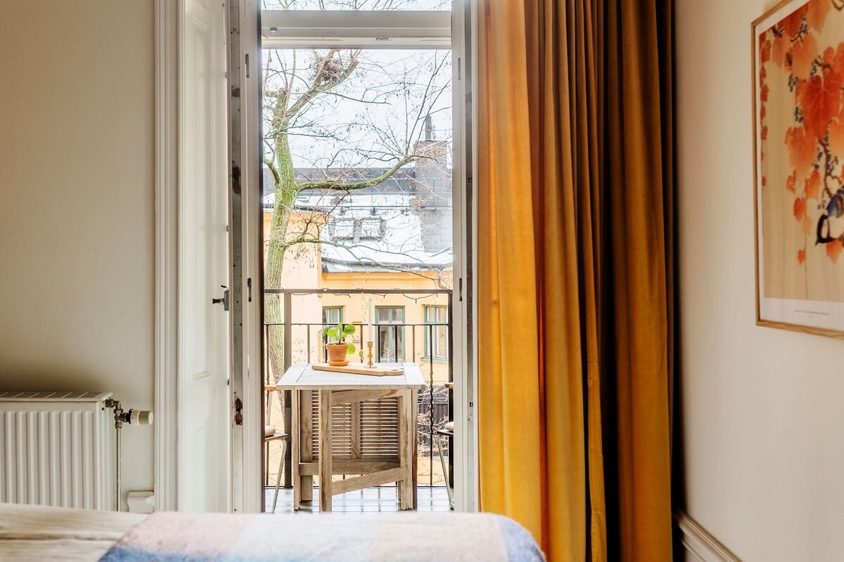 Stunning Fireplaces in a Historic Stockholm Apartment 19 ochre-yellow-curtains-bedroom-balcony-nordroom