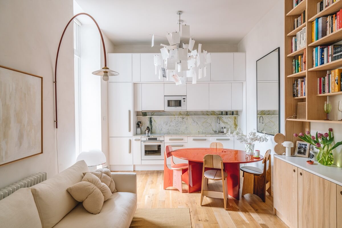 open plan living space red dining table white kitchen