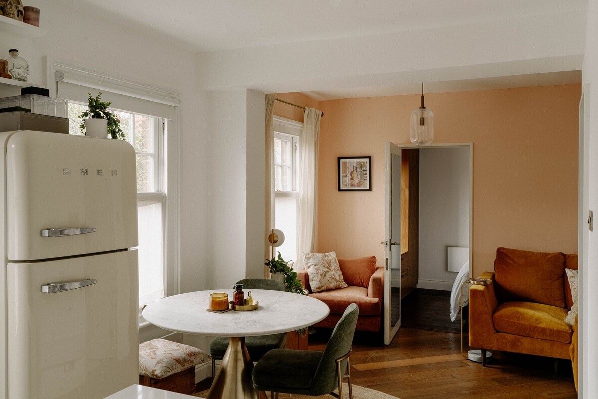 A Tiny London Apartment with Refined Materials and Colors 4 small open plan living room pink wall round dining table