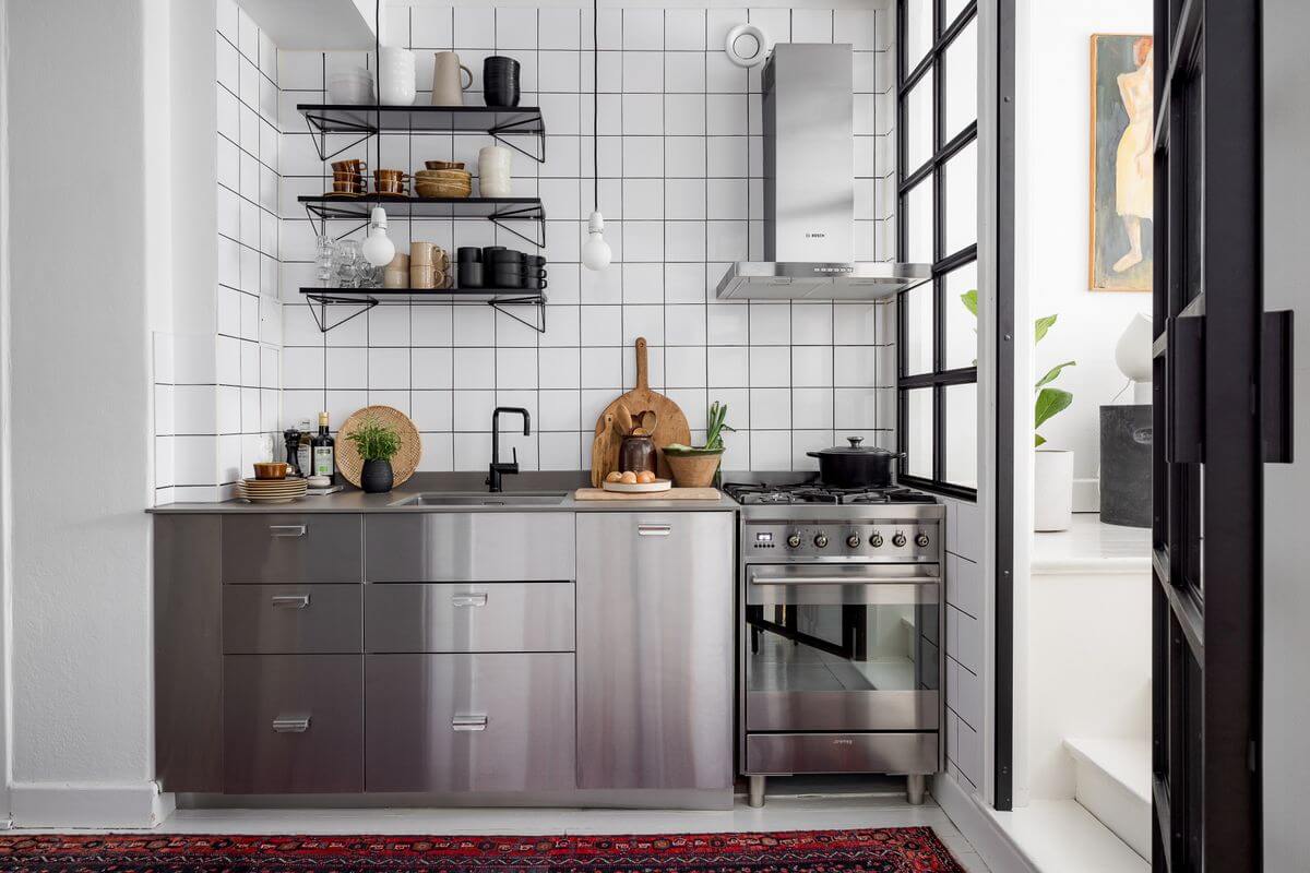 A Light Apartment with a Stainless Steel Kitchen 14 stainless steel kitchen with white tiles and pink rug