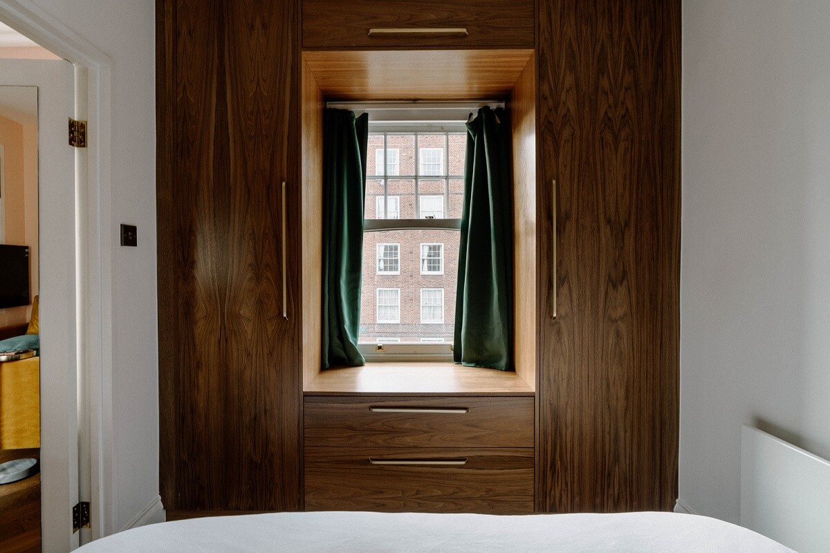A Tiny London Apartment with Refined Materials and Colors 14 tiny bedroom custom fitted walnut wardrobes green curtains nordroom