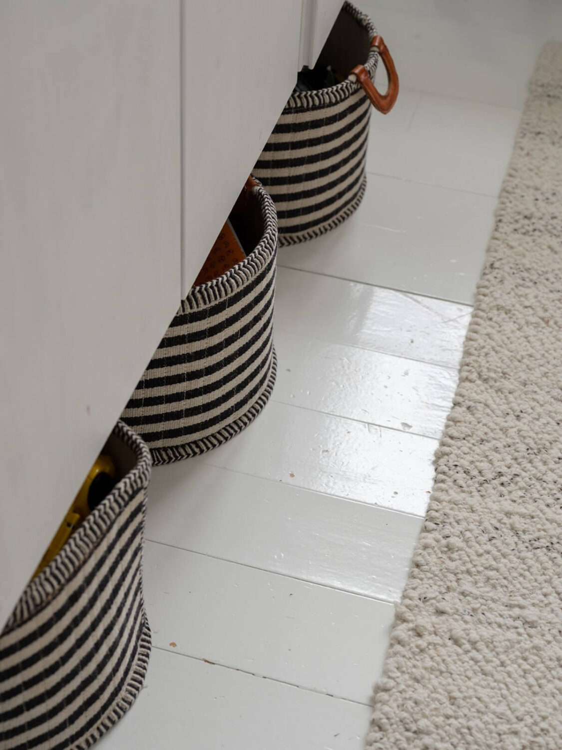 A Light Family Home in a Historic Yellow Villa 26 white floorboards striped storage bags under cabinets nordroom