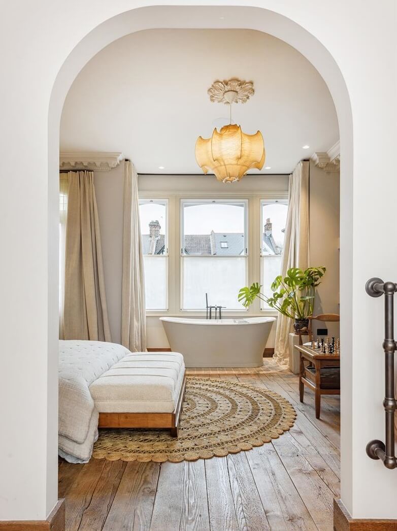 Modern Rustic Interiors in an Edwardian House in London 22 arch doorway bedroom with freestanding bath nordroom