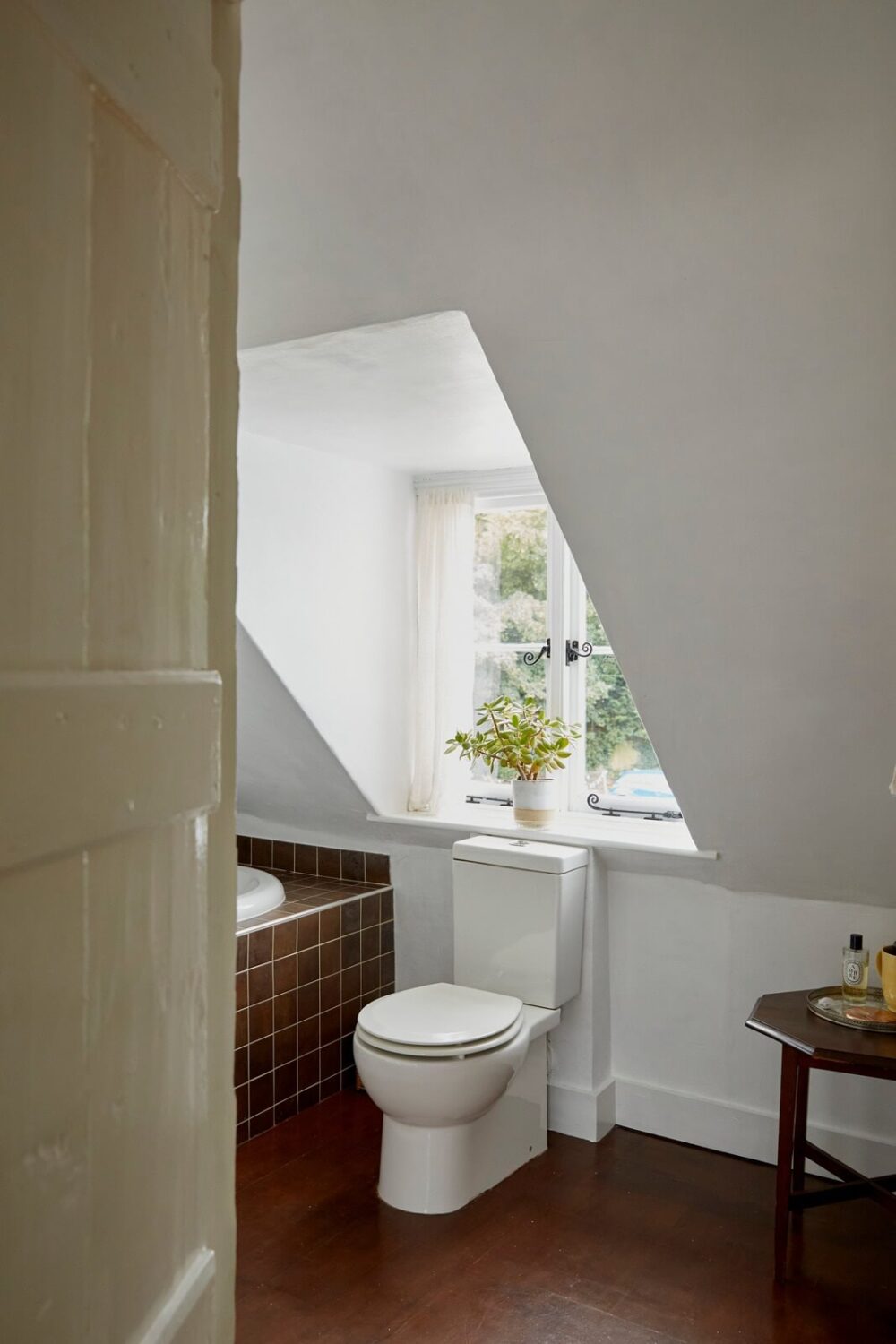A Cozy Home with Exposed Beams in a Former Post Office 13 bathroom-brown-tiles-slanted-ceiling