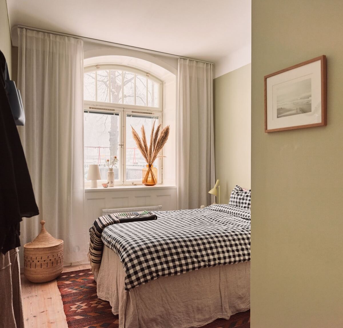 Serene Light Painted Spaces in a Swedish Apartment 13 bedroom-light-green-walls-arched-window-nordroom